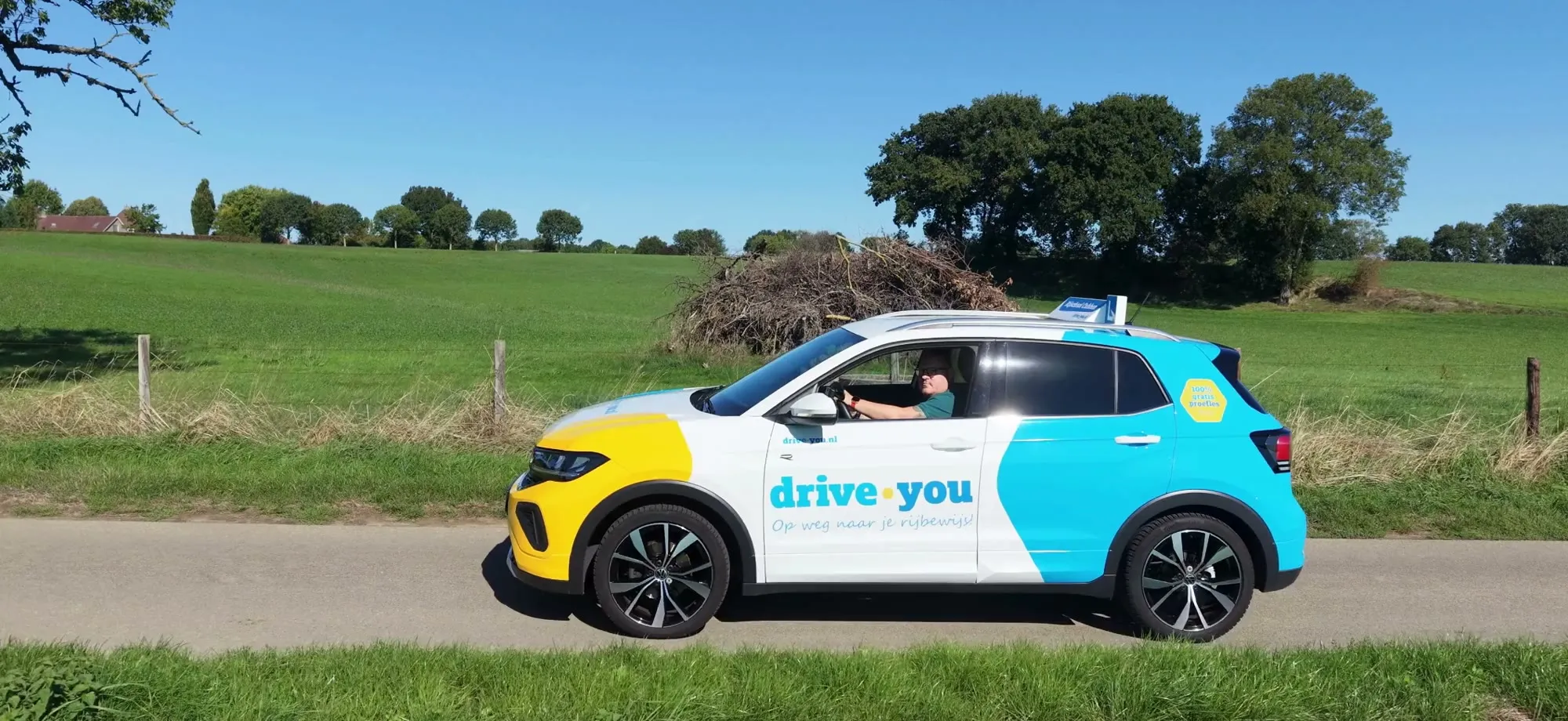 Niels Cobben rijdt in de lesauto van Rijschool Cobben over een landweg in Zuid-Limburg